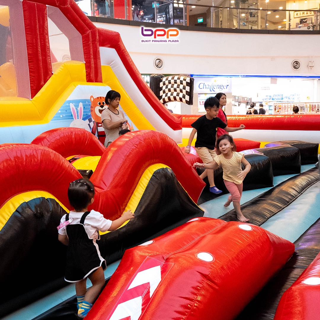 Children playing on a vibrant bouncy castle at Jumptopia Lite