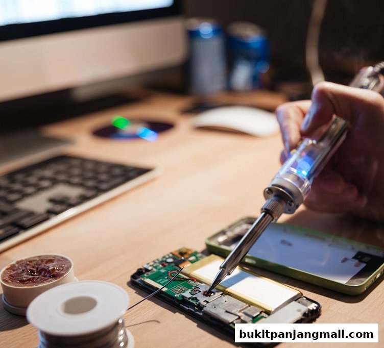 A person is soldering a phone's internal components with a soldering iron.