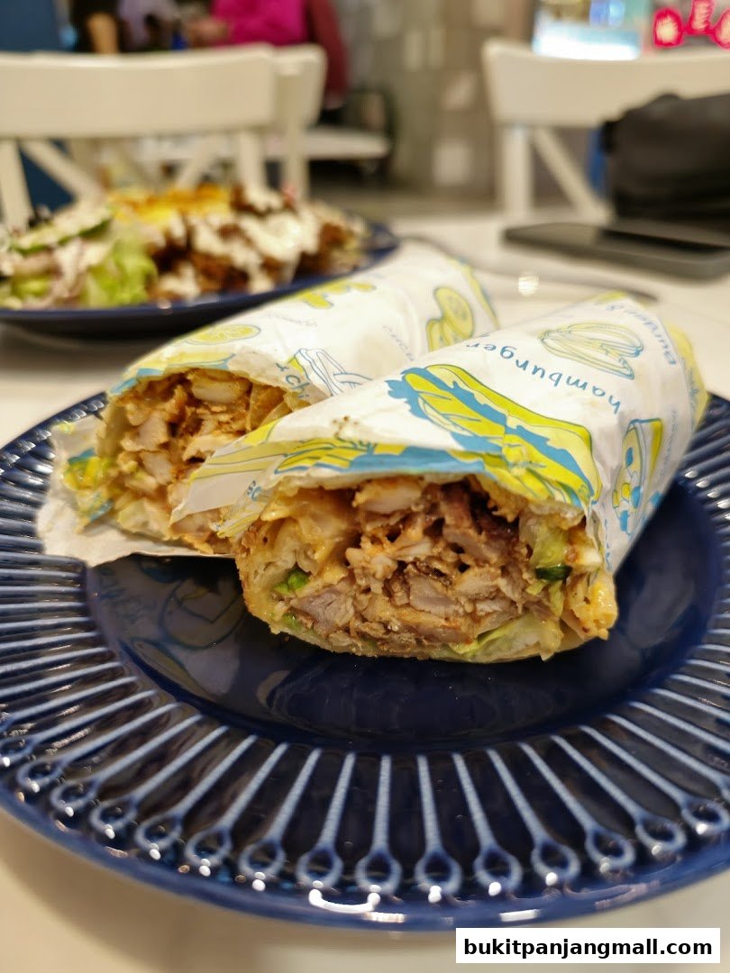 Two delicious wraps filled with meat and vegetables on a blue plate.