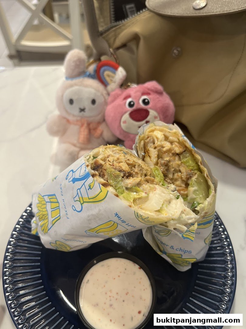 A delicious wrap with chicken and vegetables, served with a side of dip and cute plush toys.