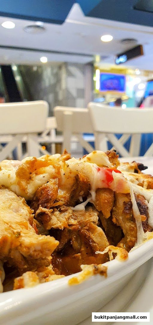A close-up of a delicious dish with grilled chicken and melted cheese.