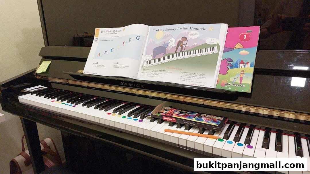 A piano with colorful stickers on the keys and music books open.