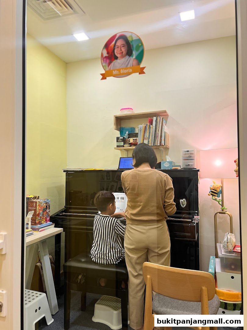 A child receives piano lessons from a teacher in a bright, well-equipped studio.