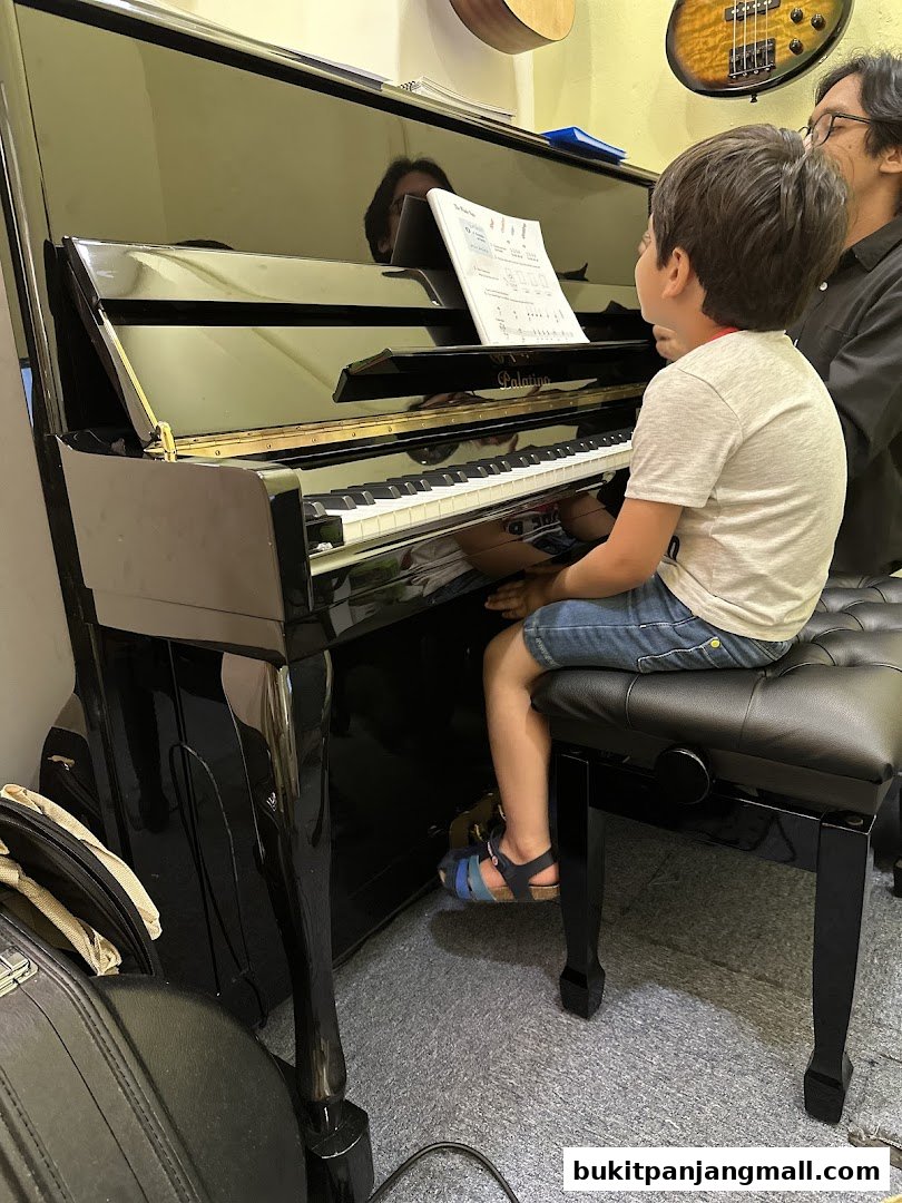A young boy receives piano lessons from an instructor at Aureus Academy.