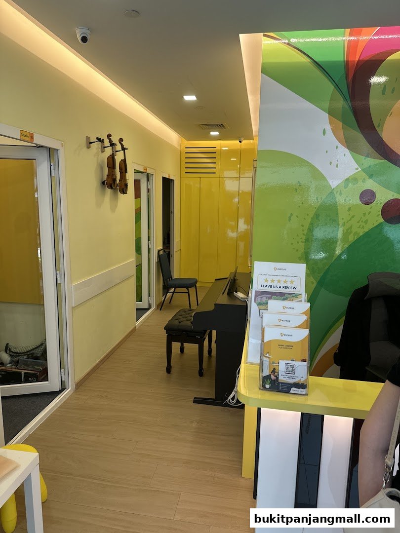 Interior hallway of Aureus Academy with music studios, pianos, and violins displayed.