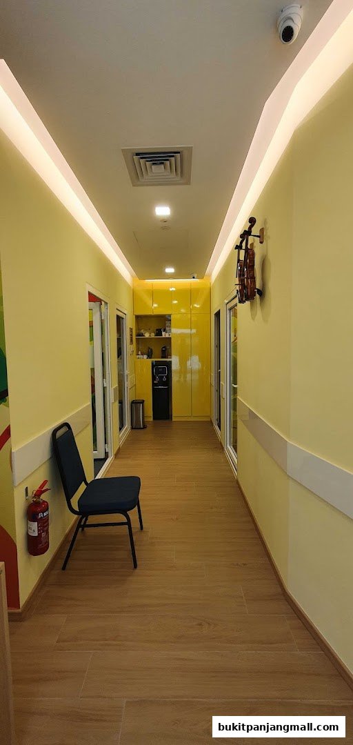 A bright yellow hallway with a chair, fire extinguisher, and a violin decoration.