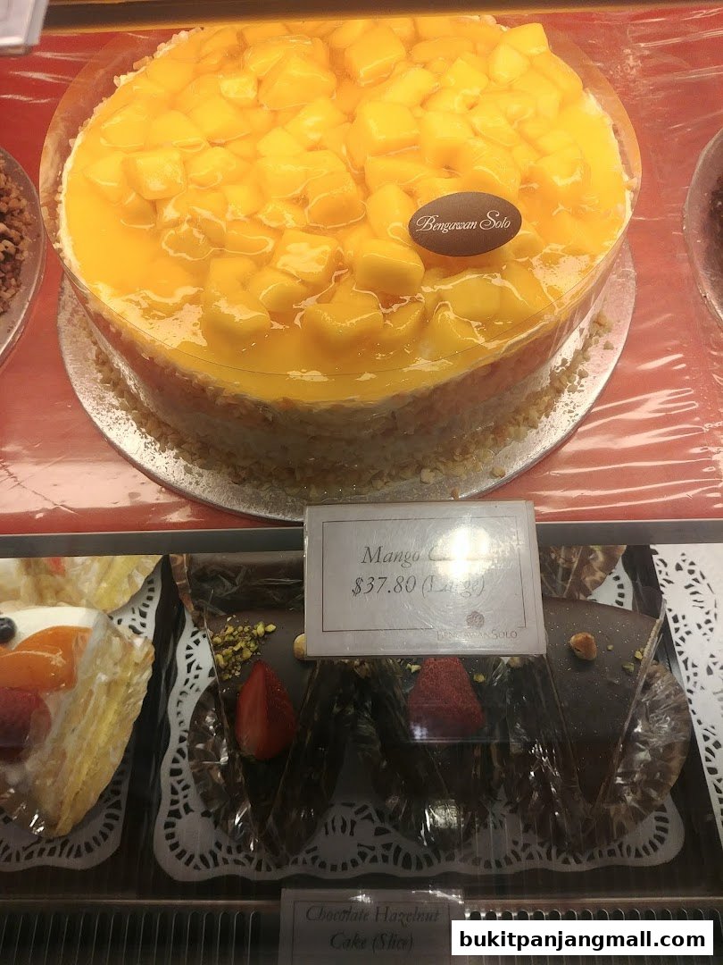 A delicious mango cake and chocolate hazelnut cake slices displayed in a bakery case.