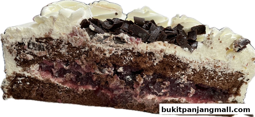 A slice of rich chocolate cake with cream and cherry filling, topped with chocolate shavings.
