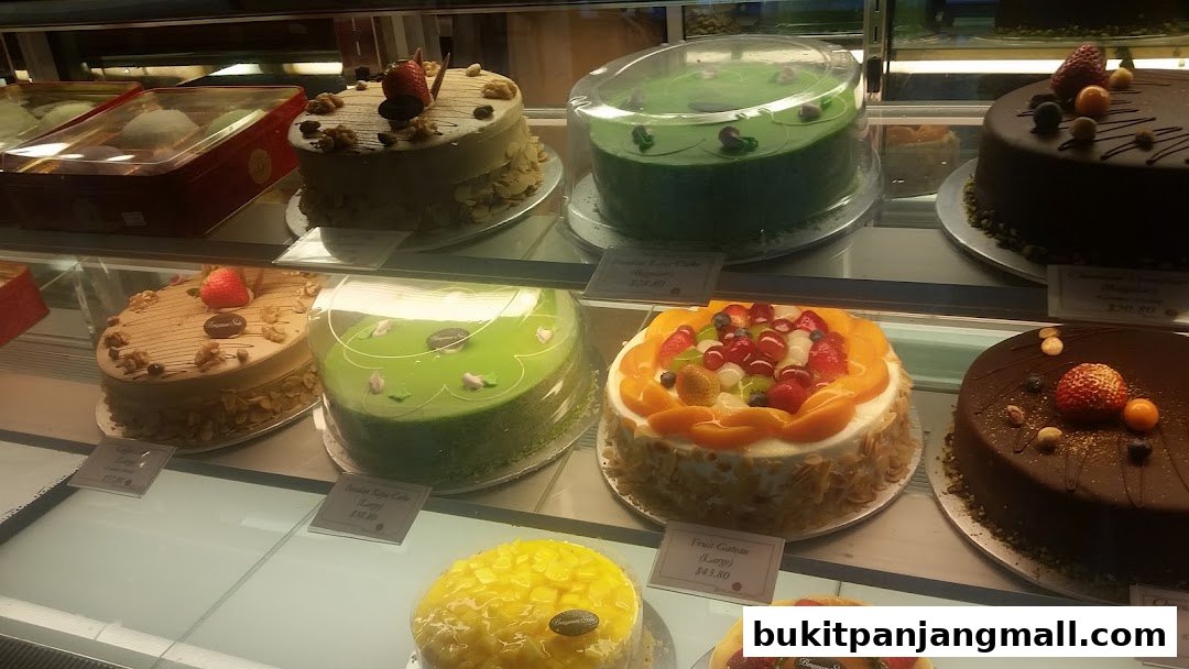 A display case filled with various beautifully decorated cakes and pastries.