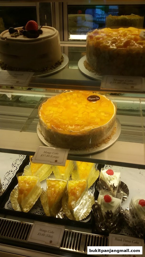 A display case filled with various cakes, including whole cakes and slices.