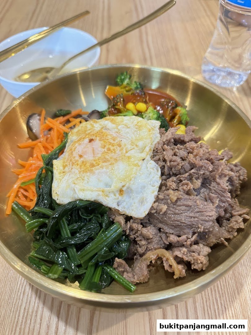 A close-up of a delicious bibimbap with beef, egg, and fresh vegetables.