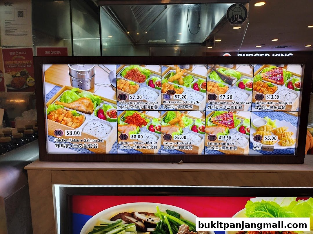 A brightly lit menu board displaying various bento box sets and gyoza.