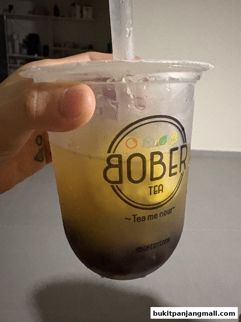 A hand holds a refreshing Bober Tea drink with the logo visible.