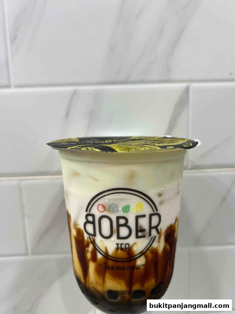 A close-up of a brown sugar bubble tea with cream topping from Bober Tea.