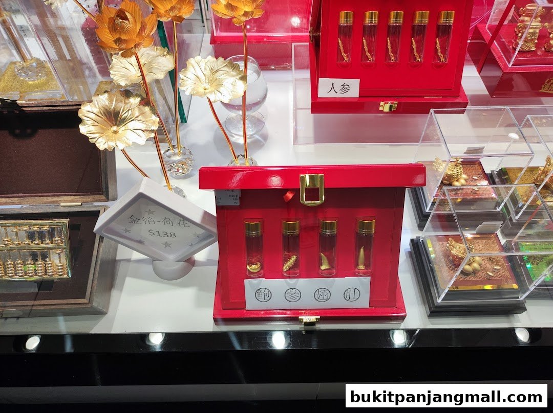 A display of various auspicious items, including golden lotus flowers, abacus, and ginseng in vials.