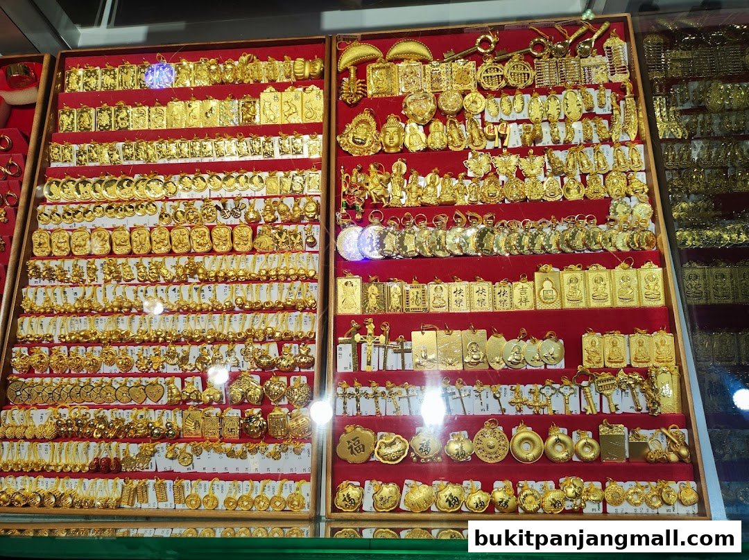 A display of numerous gold pendants and charms in various shapes and designs.