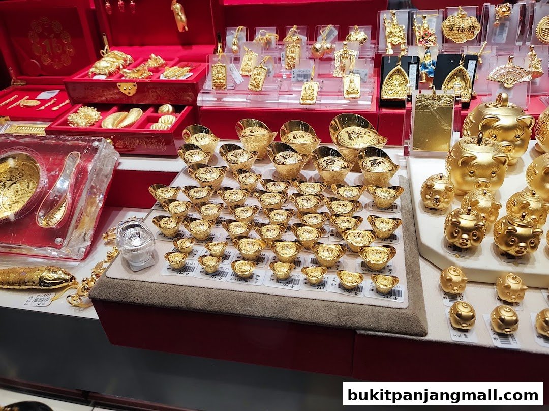 A display of various gold jewelry and ornaments, including pendants, ingots, and pig-shaped charms.