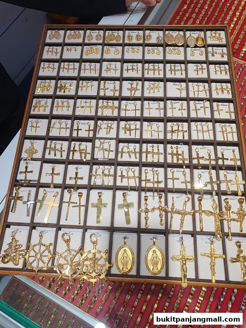 A display of various gold pendants, including crosses and religious medallions.