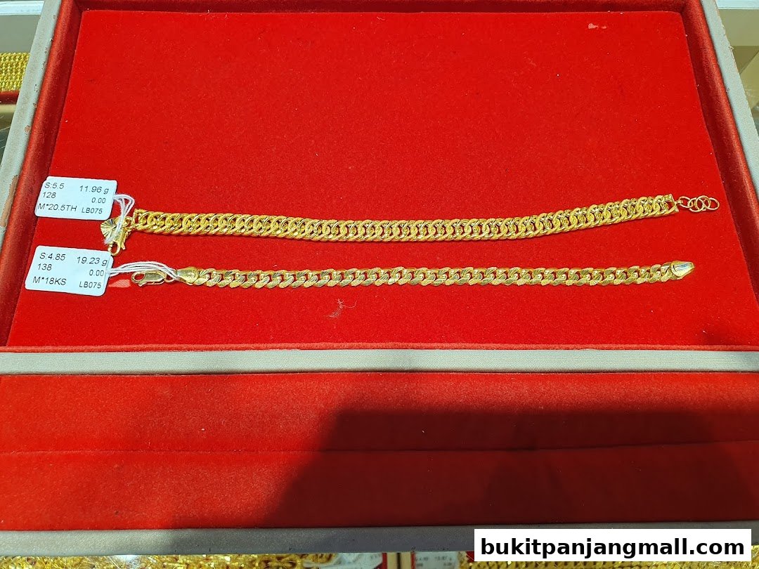 Two gold bracelets displayed on a red velvet surface with price tags.