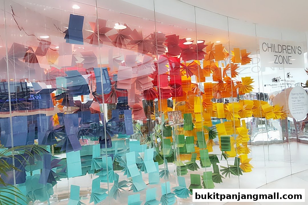 A colorful display of folded paper decorations in a rainbow gradient, adorning the entrance to a children's zone.