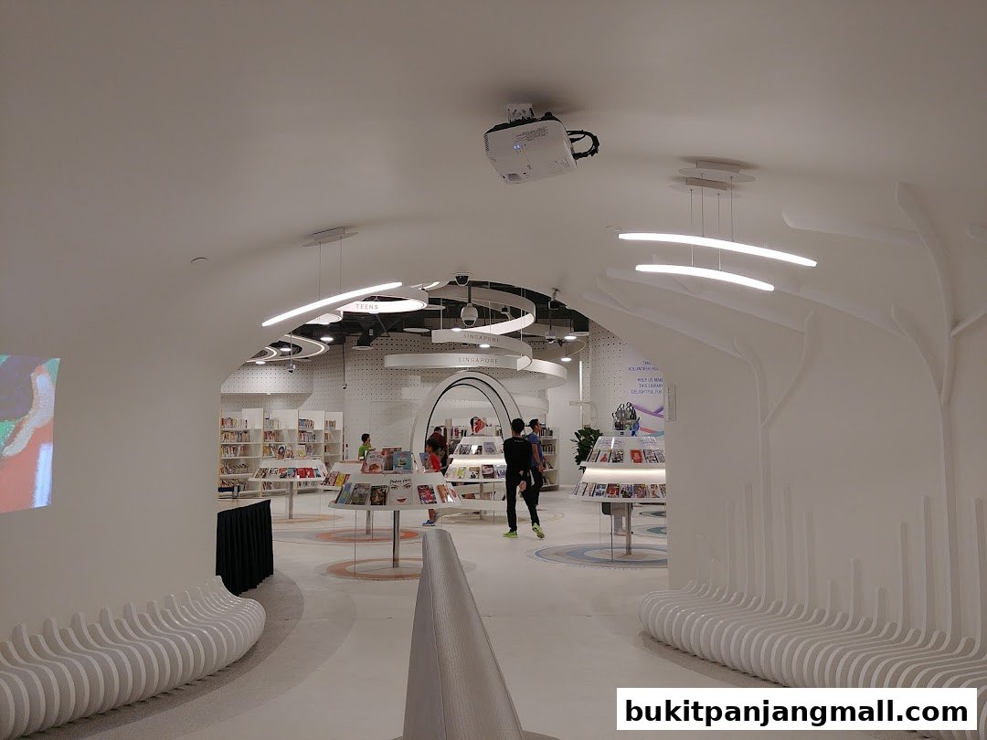 Interior view of a modern library with bookshelves, display stands, and seating areas.