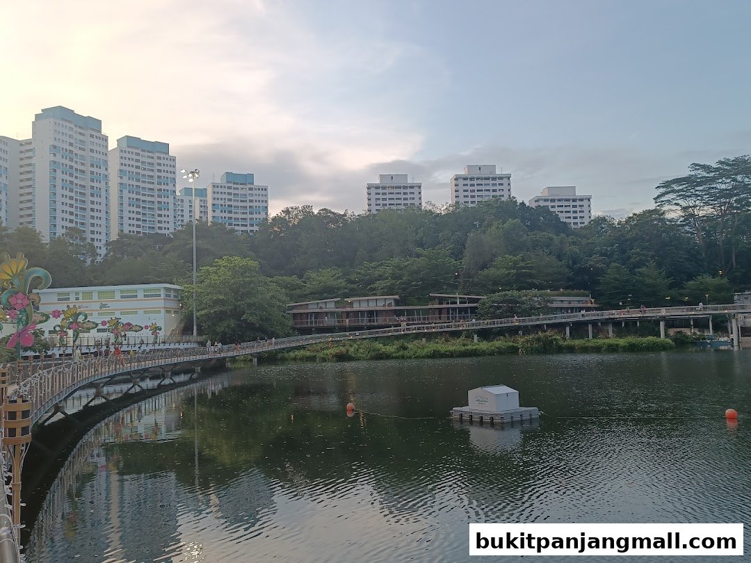A scenic view of a lake with a bridge and buildings in the background.