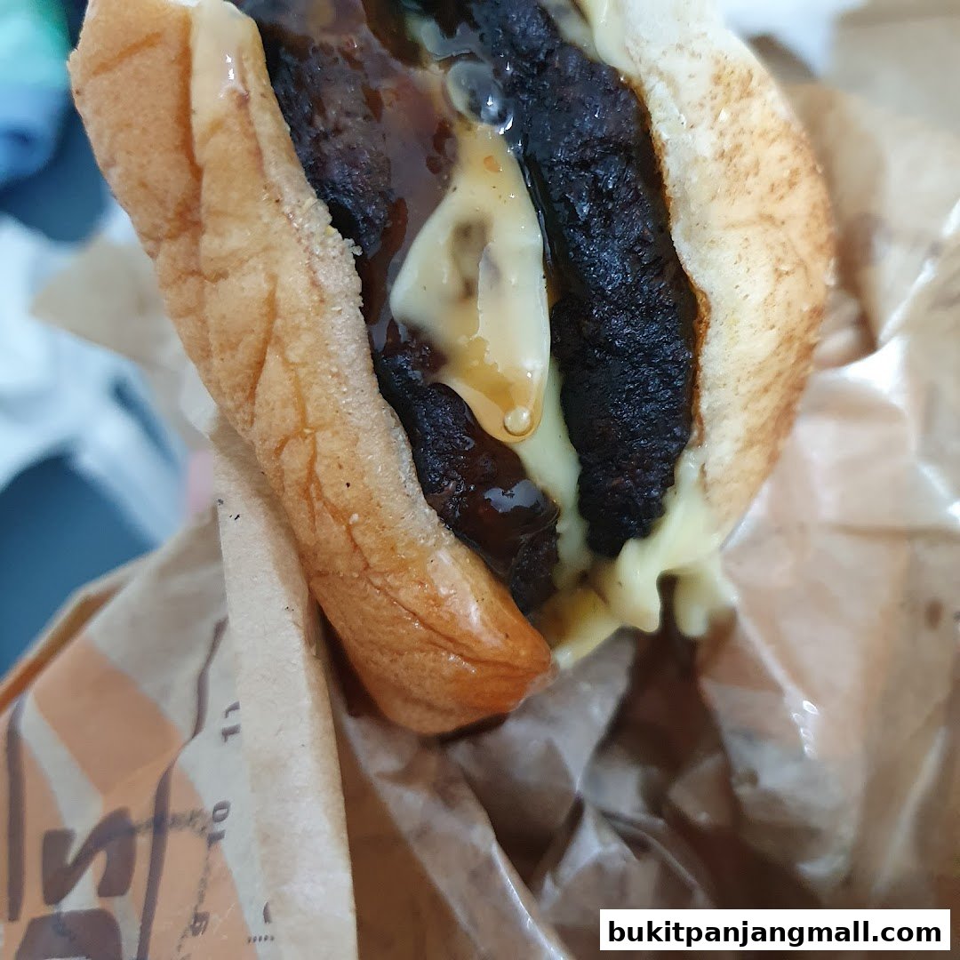 A close-up shot of a juicy Burger King Whopper with melted cheese and sauce.