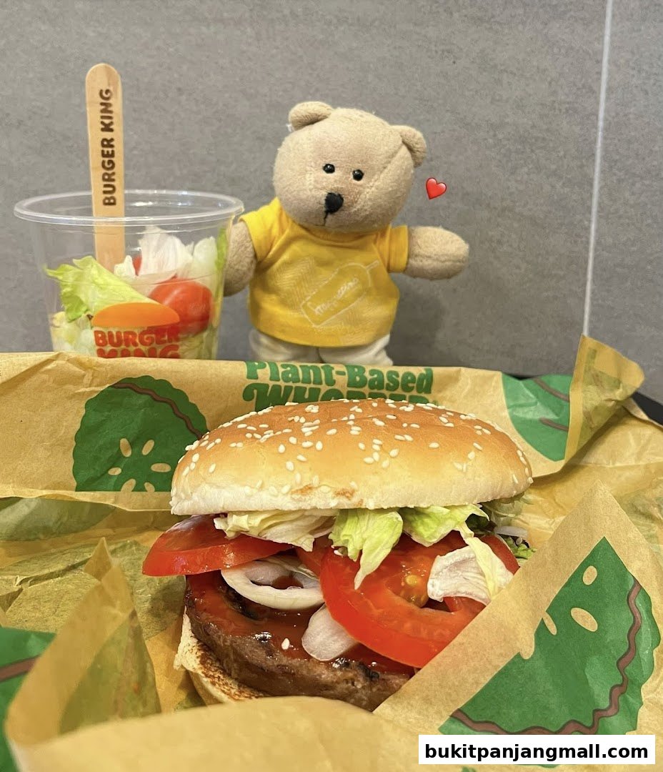 A Burger King plant-based Whopper and side salad with a teddy bear.