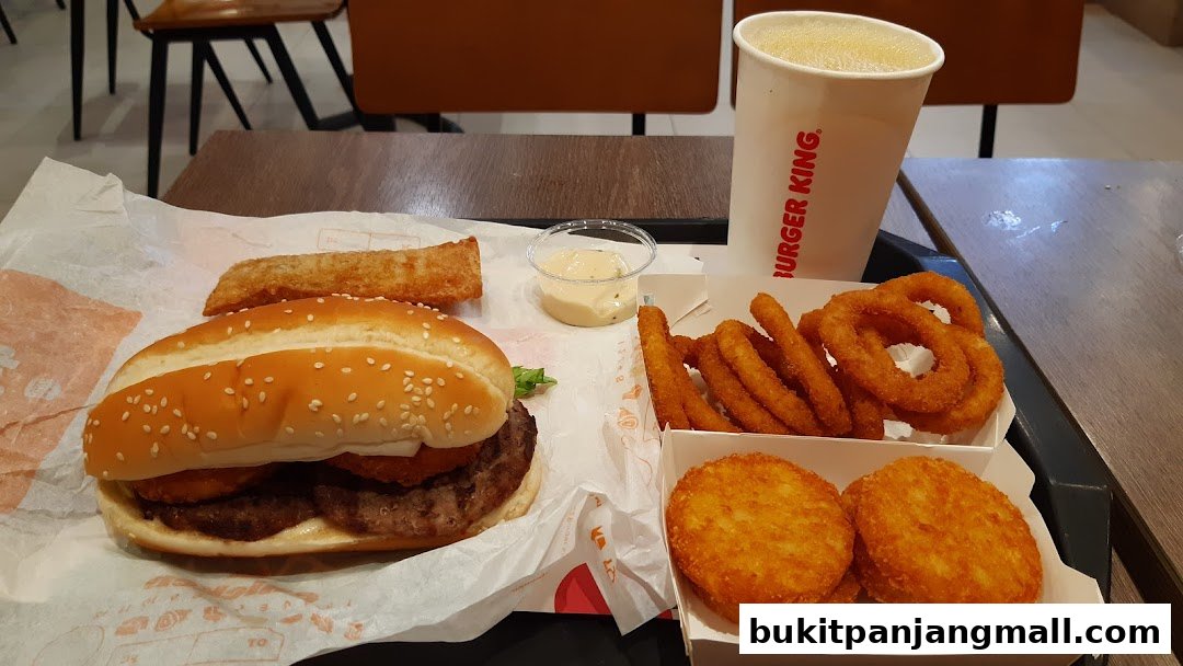 A Burger King meal featuring a double patty burger, onion rings, hash browns, a pastry, and a drink.