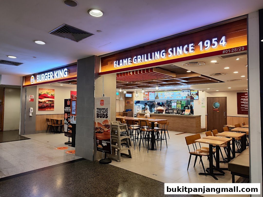 The exterior of a Burger King restaurant with seating visible inside.