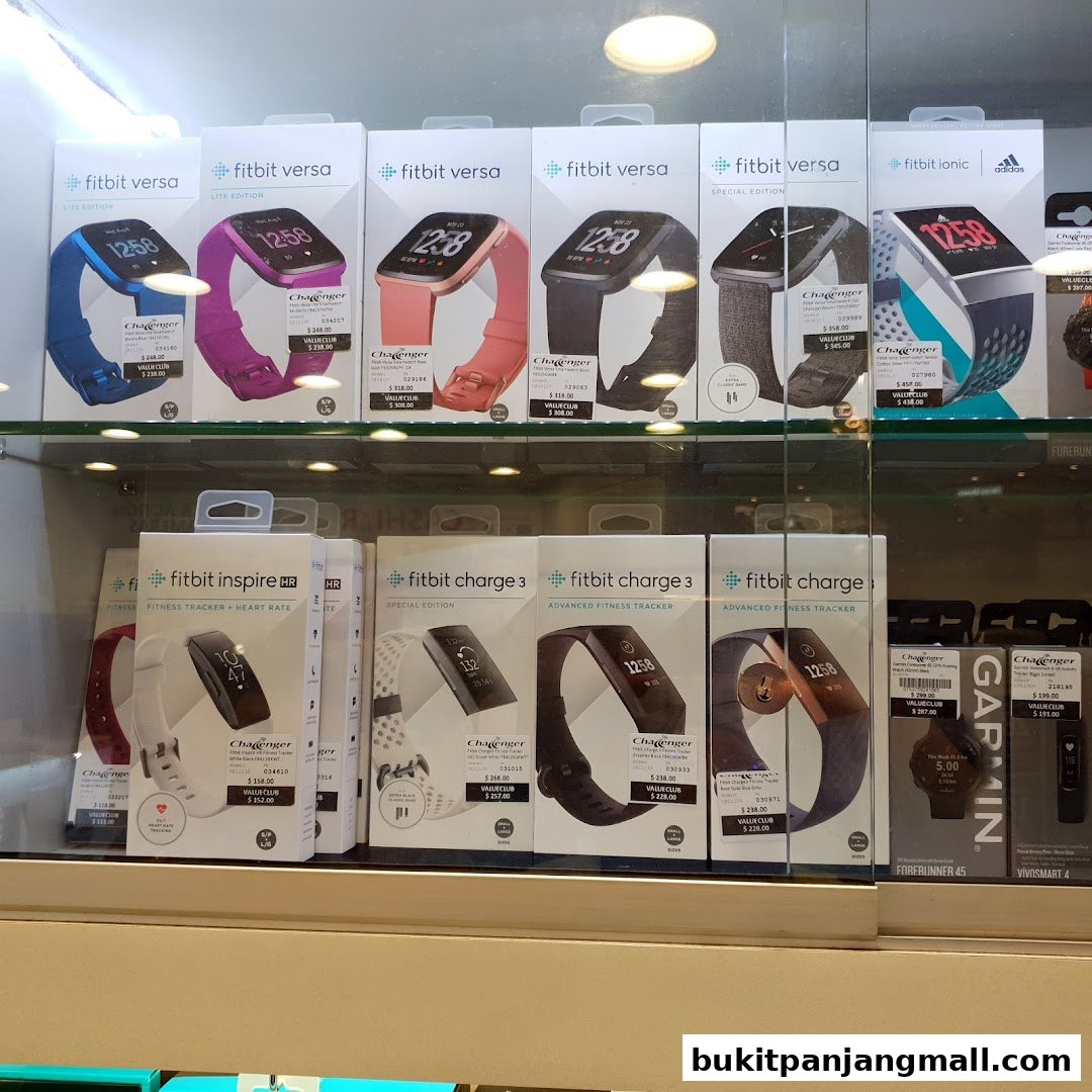 Display of various Fitbit smartwatches and Garmin smartwatches in their packaging.