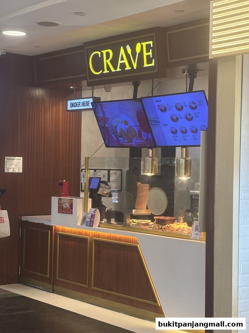 The Crave Nasi Lemak shop front with digital menus displaying food items.