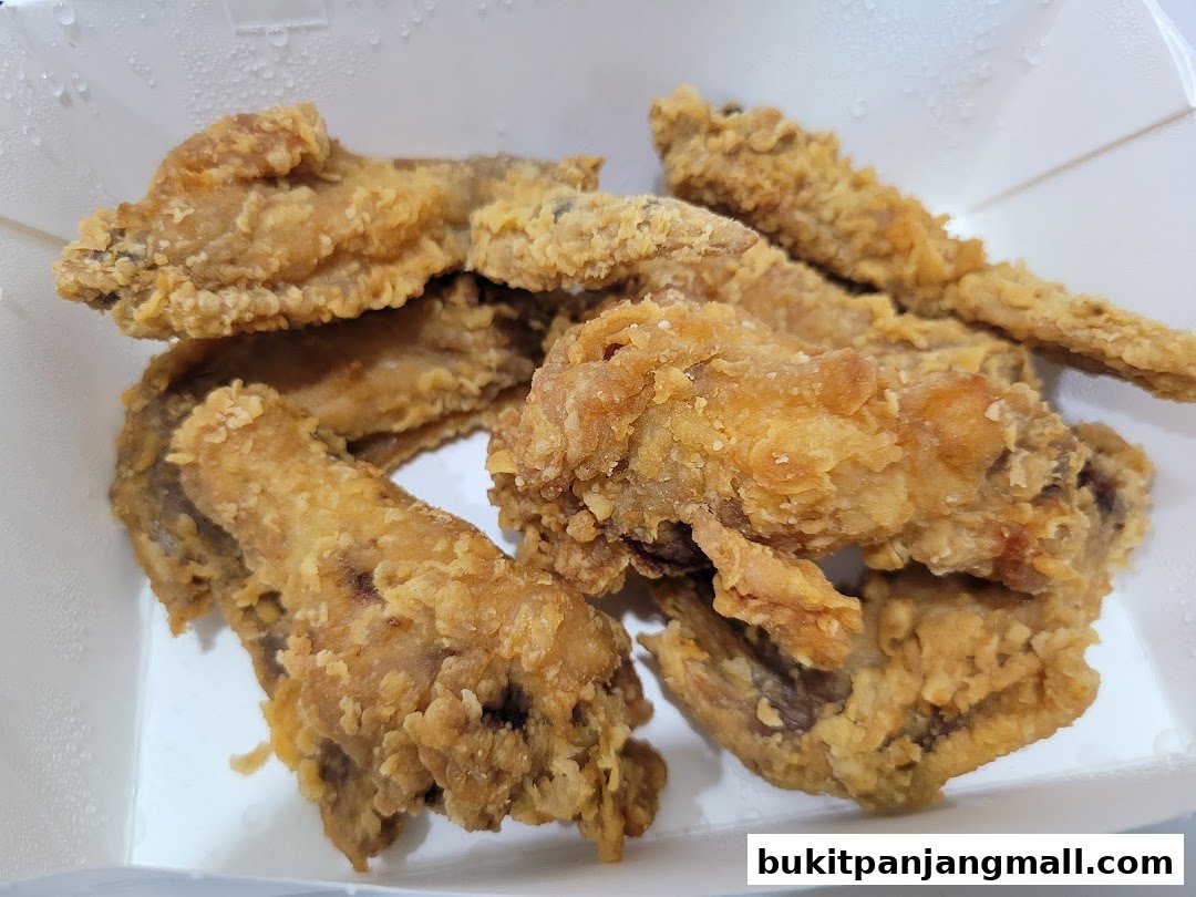 A close-up shot of crispy, golden-brown Korean fried chicken pieces in a white box.