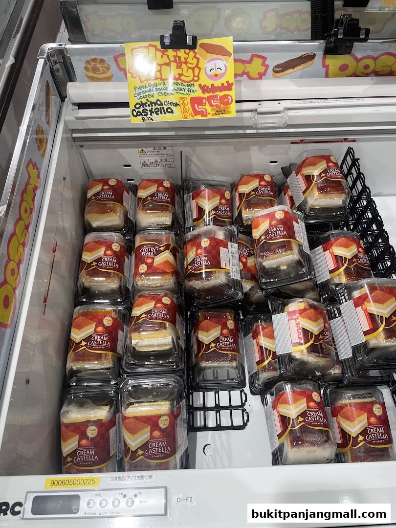 A display of individually packaged Cream Castella cakes in a refrigerated unit.