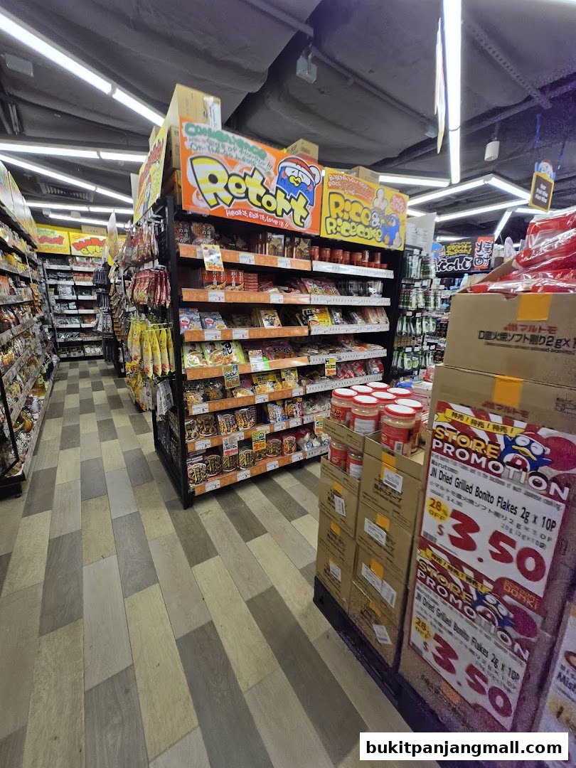 Aisle of a Japanese supermarket with shelves stocked with snacks and food products.