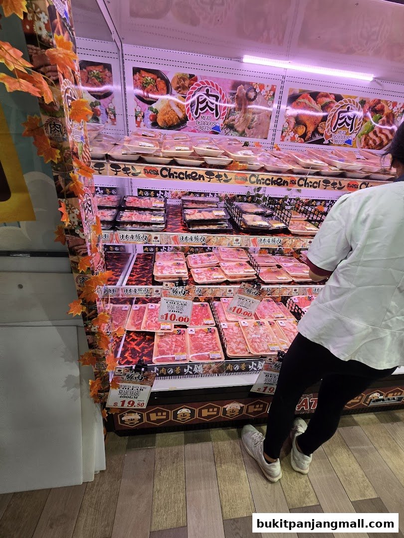 A display of fresh meats, including chicken and beef, in a retail store.