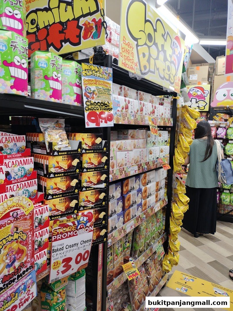 Aisle of snacks and sweets with colorful packaging and promotional signs.