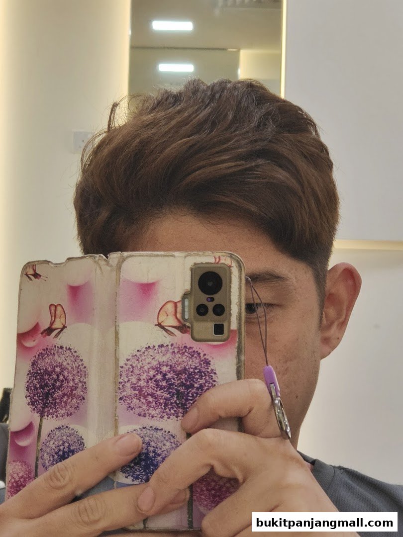 A person holds a phone with a floral design, reflecting in a mirror.