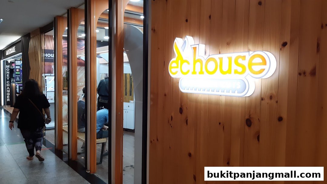 The exterior of EC House, a hair salon, with a prominent illuminated logo on a wooden wall.