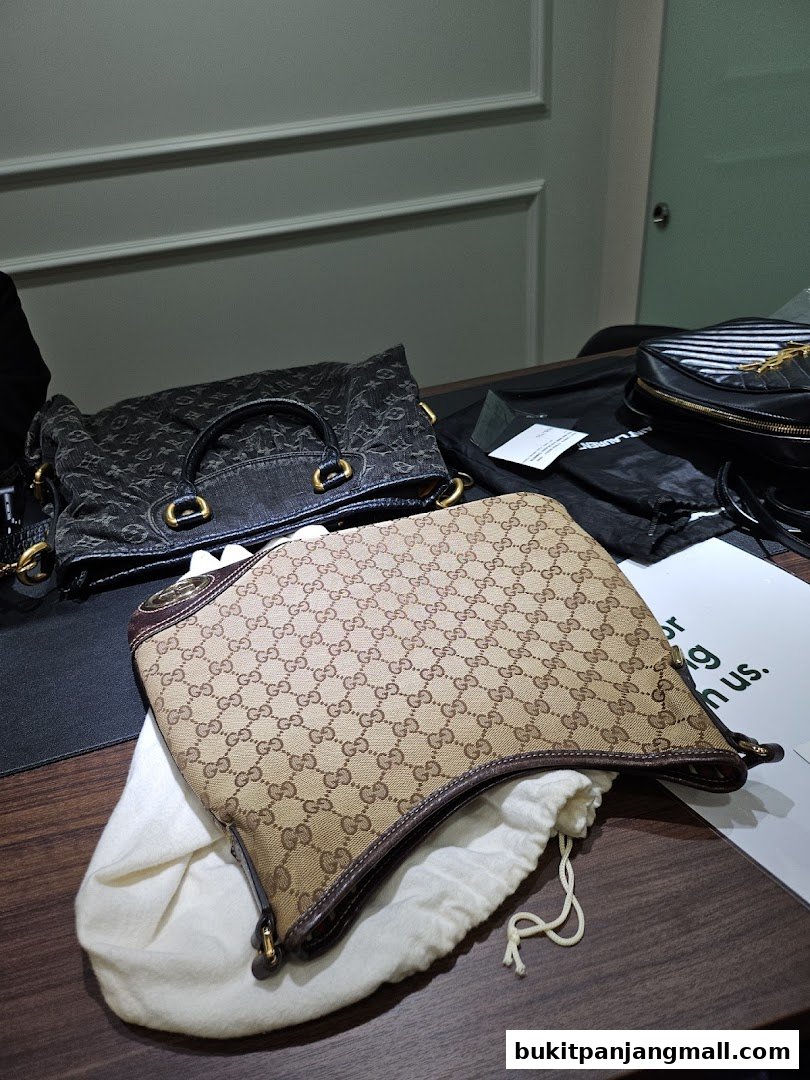 A collection of designer bags, including Gucci and Saint Laurent, displayed on a table.