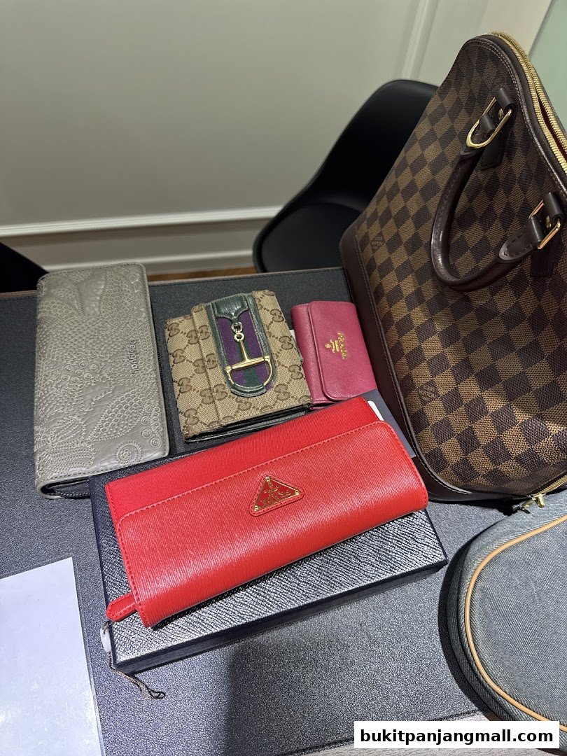 A collection of luxury branded wallets and a handbag displayed on a table.
