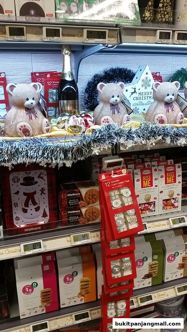 A festive display of Christmas-themed products including teddy bears, champagne, and cookies.