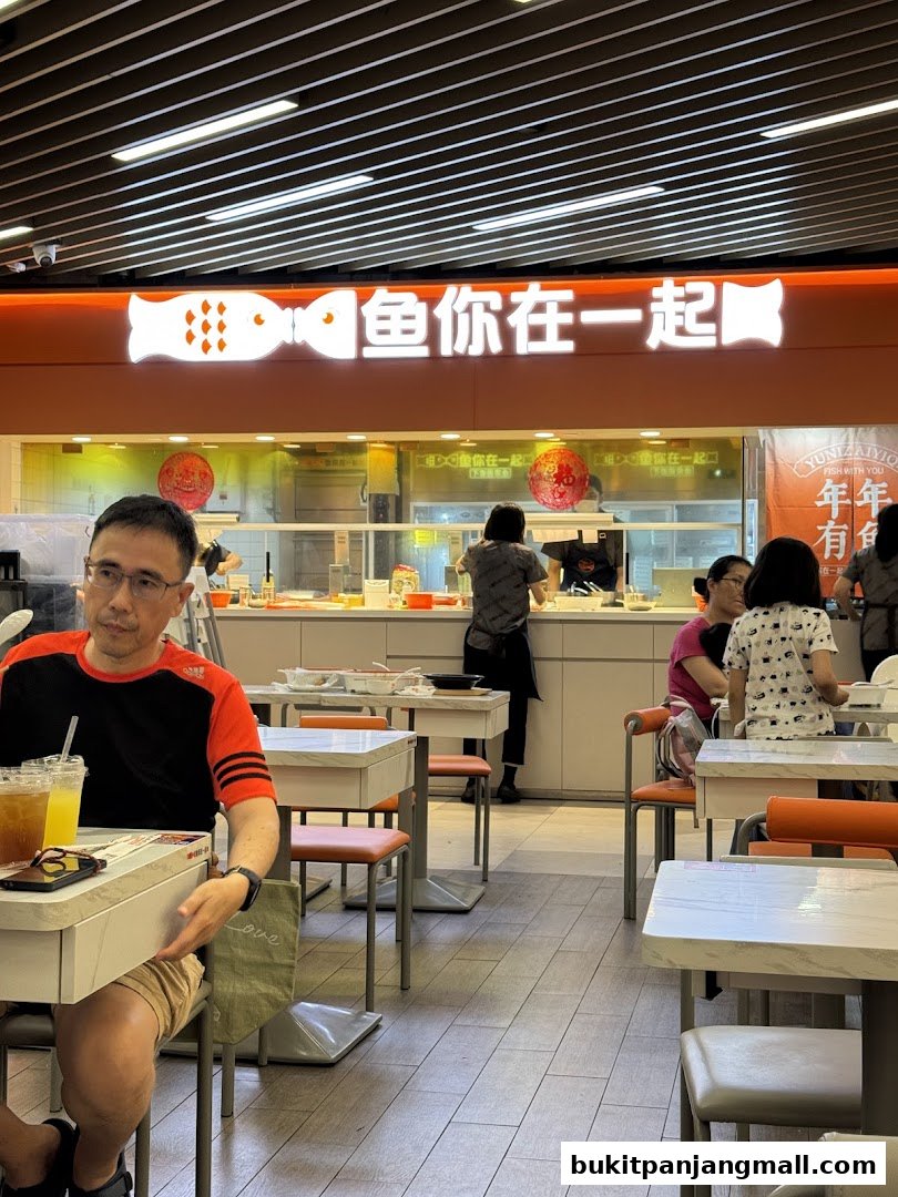 Interior of a restaurant with customers dining and staff behind the counter.