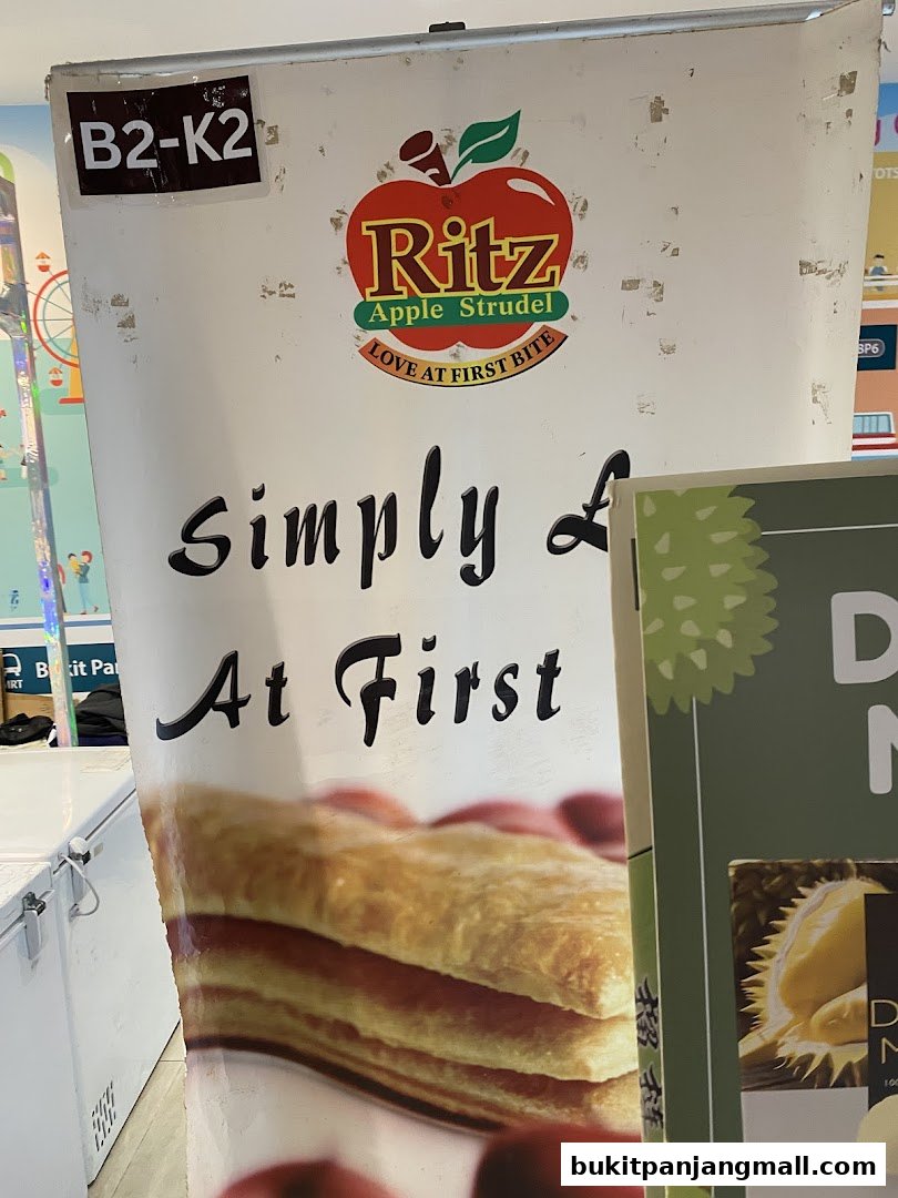 A sign for Ritz Apple Strudel with a picture of the pastry and text.