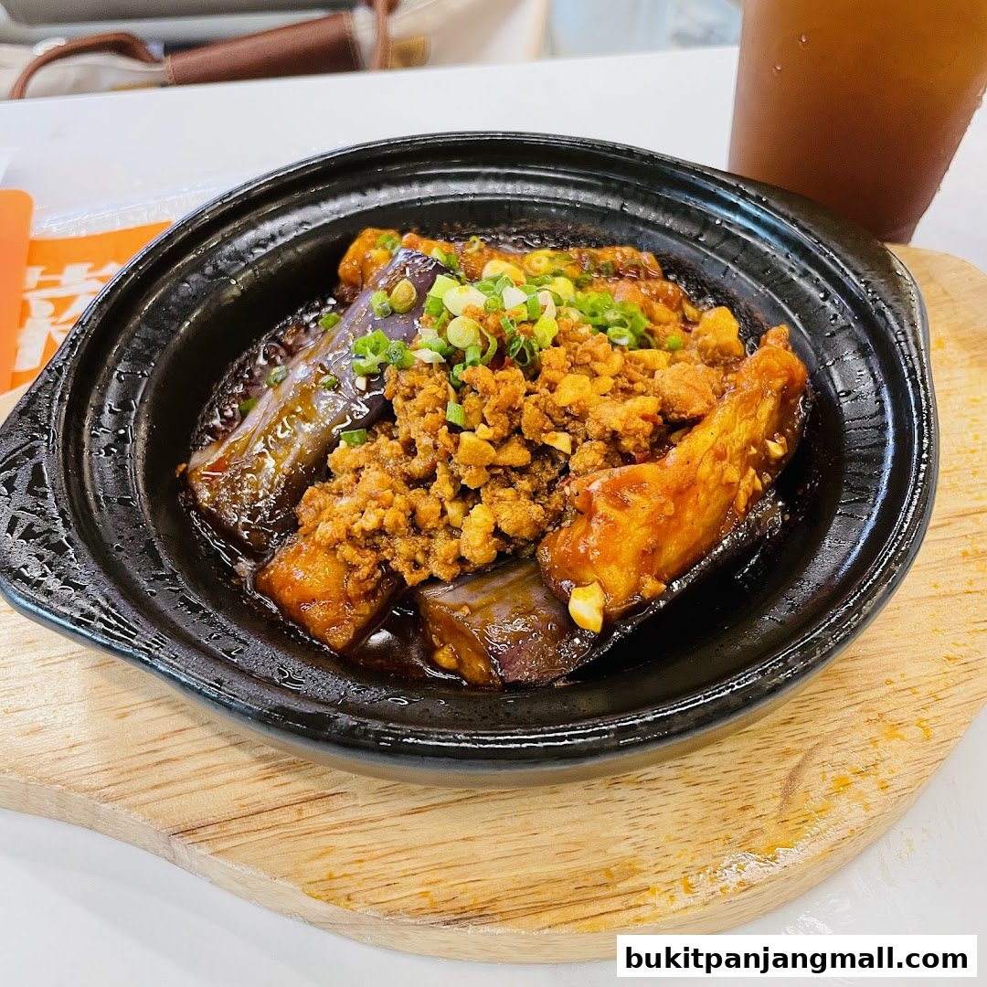 A close-up of a savory dish with eggplant and minced meat, garnished with green onions.