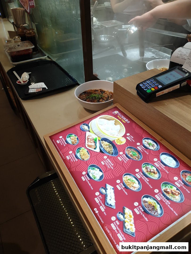 A close-up of a menu board displaying various noodle and dumpling dishes with prices.