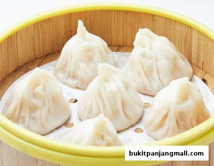 A close-up shot of delicious soup dumplings served in a bamboo steamer.