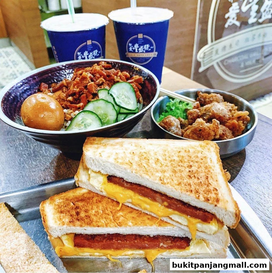 A close-up shot of a meal featuring sandwiches, a bowl of rice with toppings, and fried chicken.