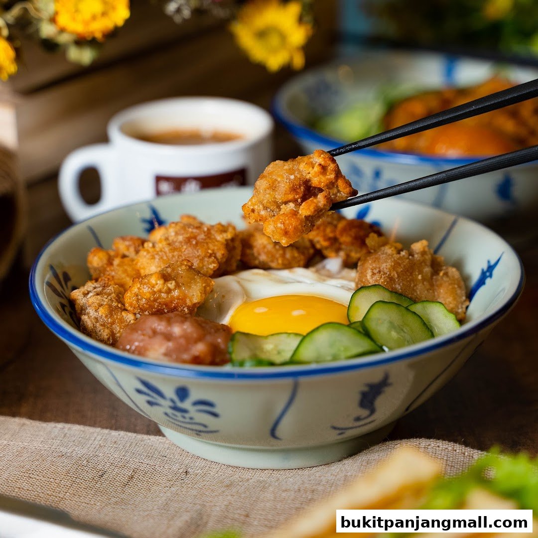 A close-up of a delicious Taiwanese fried chicken rice bowl with a sunny-side-up egg and cucumber.