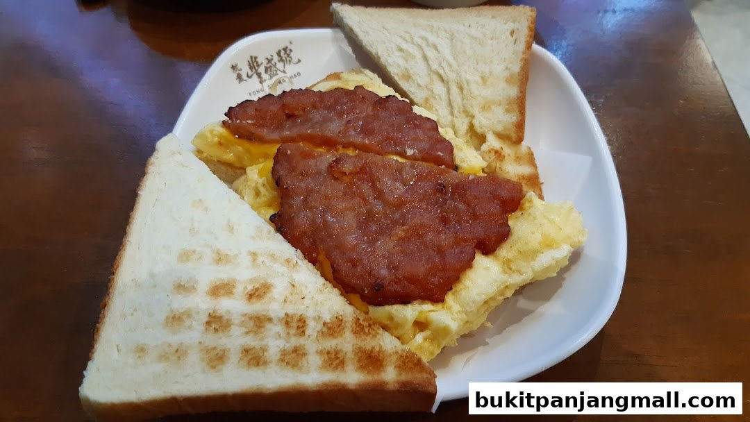 A close-up of a breakfast dish with toast, scrambled eggs, and meat.